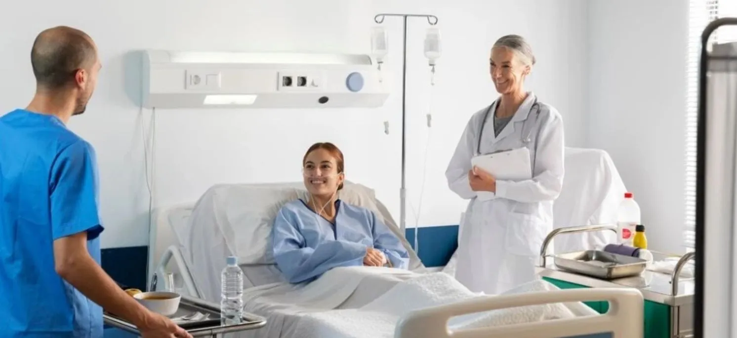 Chica sentada hablando con una médico y un enfermero en un entorno clínico